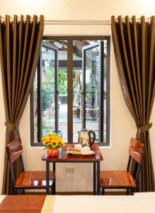 a dining room with a table and a window at Nam Nhung Tam Coc Homestay in Ninh Binh