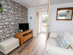 a living room with a white couch and a stone wall at Field View in Llanybydder