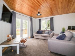 a living room with two couches and a wooden ceiling at Lodge One in Truro