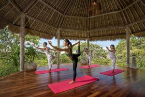 een groep mensen die yoga doen in een paviljoen bij The Mesare Eco Resort in Nusa Penida