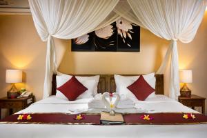 a bedroom with a bed with a swan on it at The Mesare Eco Resort in Nusa Penida