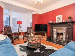 a living room with a fireplace and a tv at Rhiwlas in Rhosneigr