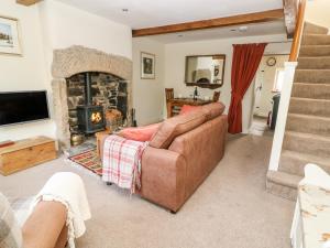 ein Wohnzimmer mit einem Sofa und einem Kamin in der Unterkunft Foxglove in Keighley