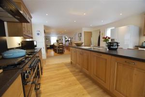 Una cocina grande con gabinetes de madera y encimera. en Gwelfor, Newport, en Newport