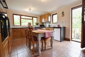 a kitchen with a table and some chairs in it at Mill Barn Denant in Haverfordwest