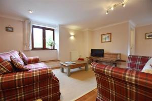 a living room with two couches and a table at Mill Barn Denant in Haverfordwest