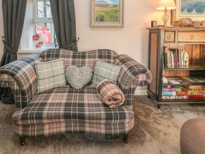 ein Sofa mit Kissen darauf im Wohnzimmer in der Unterkunft Petty Knowes Cottage in Newcastle upon Tyne