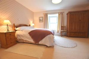 a bedroom with a large bed and a window at Tremynydd Fawr in St. Davids