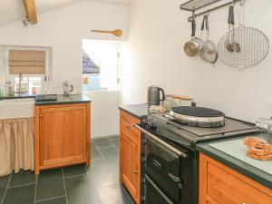 a kitchen with a stove and a counter top at Howgill Cottage in Sedbergh