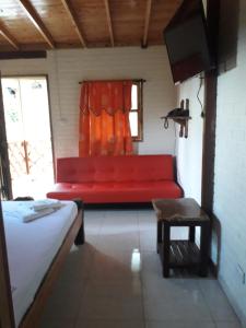a red couch in a room with a window at Alojamiento Campestre Cabañas Mirador Ingrumá Riosucio Caldas in Ruiosucio
