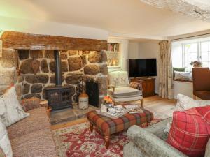 a living room with a stone fireplace and a couch at Rookwood in Exeter