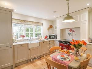 une cuisine avec une table et un vase de fleurs dans l'établissement Rookwood, à Exeter