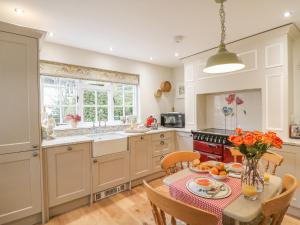 a kitchen with a table with a vase of flowers at Rookwood in Exeter