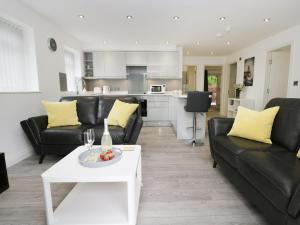 a living room with black leather furniture and a white table at The Office Gardens, Apartment 1 in Whitby