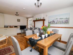 a dining room with a wooden table and chairs at Manor Cottage in Northallerton