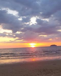 a sunset on the beach with the sun setting at Leisure homestay@Kota Kinabalu in Kota Kinabalu