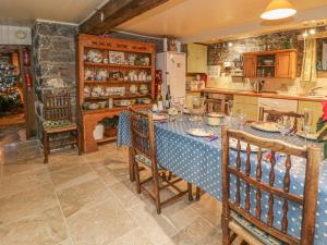 cocina con mesa y mantel azul en Lower Dolgenau- The Cottage, en Caersws