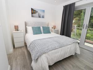 Un dormitorio blanco con una cama y una ventana. en The Office Gardens, Apartment 2, en Whitby