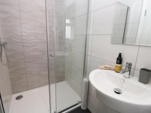 Un baño blanco con ducha y lavabo. en The Office Gardens, Apartment 2, en Whitby 10 fotos más