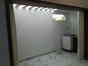 a bathroom with a white wall and a window at Yaa Residency near VIT in Vellore