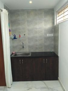 a kitchen with a sink and a counter top at Yaa Residency near VIT in Vellore