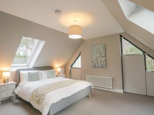 a bedroom with a large bed and two windows at Osprey Apartment in Kingussie