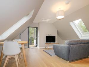 a living room with a couch and a tv at Osprey Apartment in Kingussie