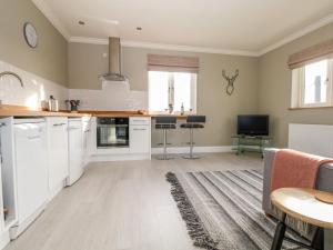 a kitchen with white cabinets and a table at Roughwood in Ringwood