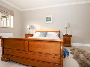 a bedroom with a wooden bed and two night stands at Roughwood in Ringwood