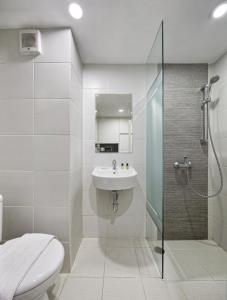 a bathroom with a toilet and a sink and a shower at Sakura Terrace in Jakarta