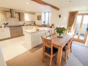 a large kitchen with a wooden table and chairs at Grange Cottage in Crediton