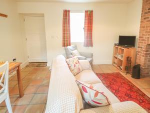 a living room with a couch and a tv at Robertson's Cottage in Caledon