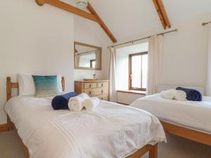a bedroom with two beds with towels on them at The Honeypot Cottage in Penzance