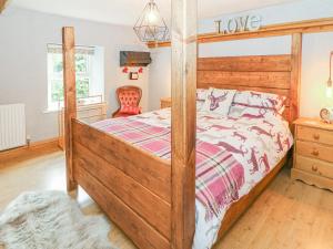 um quarto com uma cama de madeira com uma estrutura de madeira em Linden Lea em Kirkby Stephen
