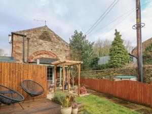 a patio with chairs and a wooden fence at Linden Lea in Kirkby Stephen