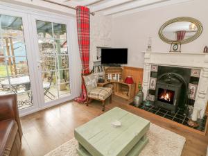 a living room with a fireplace and a tv at Linden Lea in Kirkby Stephen