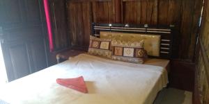 una camera da letto con un letto con un oggetto rosso sopra di Made Roejas Homestay a Uluwatu