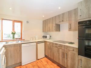 a kitchen with wooden cabinets and a sink at The Wagon Linney in Bude