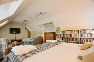 a living room with a large bed and book shelves at Beach Retreat in Aberporth