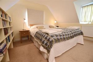 een slaapkamer met een bed en een boekenplank bij Beach Retreat in Aberporth