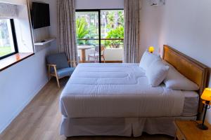 a hotel room with two beds and a balcony at Hotel Palmas de La Serena in La Serena