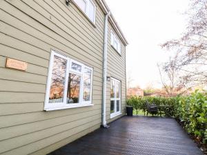 a house with a wooden porch and two windows at Arnside House in Carnforth