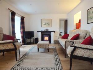 a living room with a couch and a fireplace at Beach Cottage in Little Haven