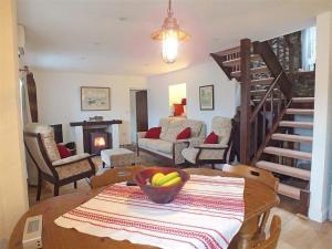 a living room with a table with a bowl of fruit on a table at Beach Cottage in Little Haven