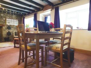 a dining room table with a laptop computer on it at Granston Cottage in Granston