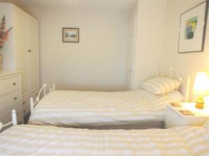 a bedroom with two beds and a dresser and a bedsenalsenalsenalsenal at Granston Cottage in Granston