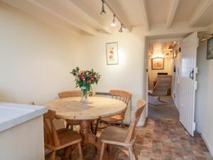 a kitchen and dining room with a table and chairs at 3 Rose Cottages in Looe