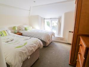 ein Schlafzimmer mit zwei Betten und einem Fenster in der Unterkunft 3 Rose Cottages in Looe