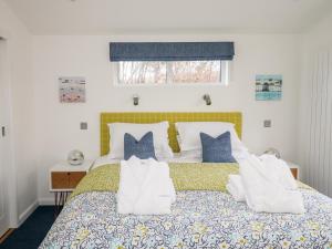 1 dormitorio con cama con almohadas y ventana en 2 Valley View, en Looe