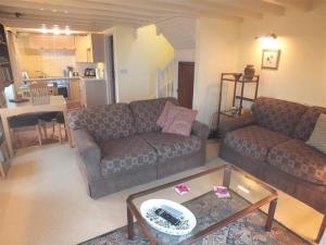 a living room with two couches and a table at Cockshead Cottage in Saint Dogmaels